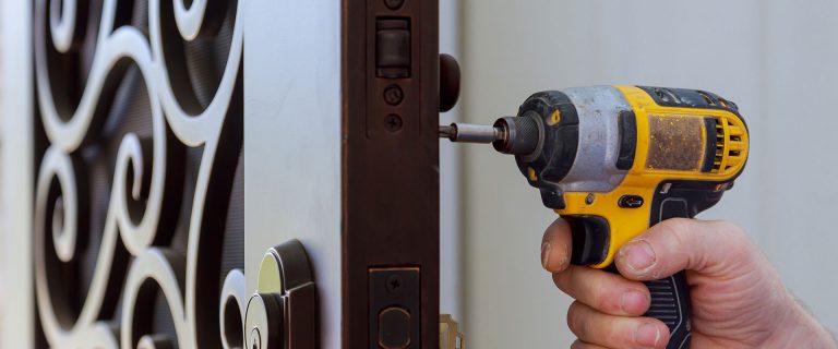 New house hand close-up builder in installing a door lock the door of a new house