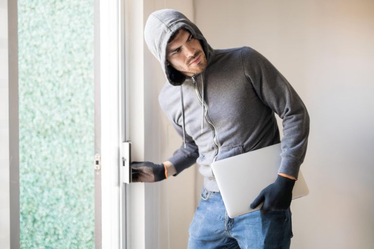 hispanic-male-criminal-stealing-laptop-computer-walking-away-unnoticed