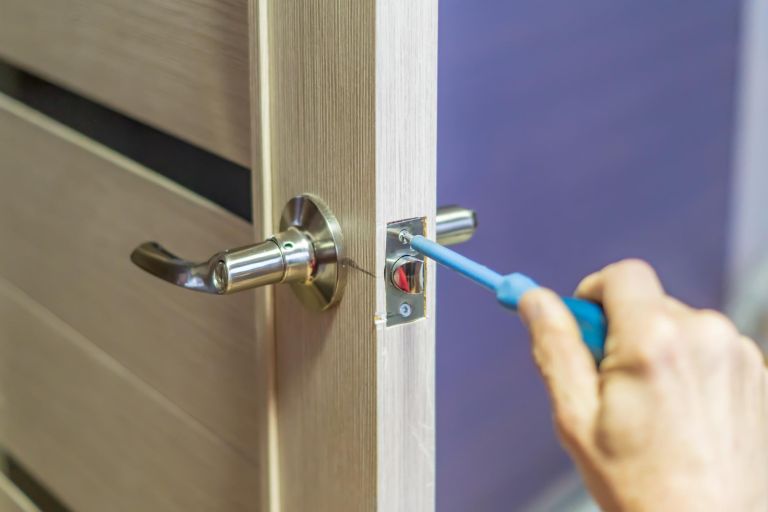 man-repairing-doorknob-with-screwdriver-workers-hand-installing-new-door-locker